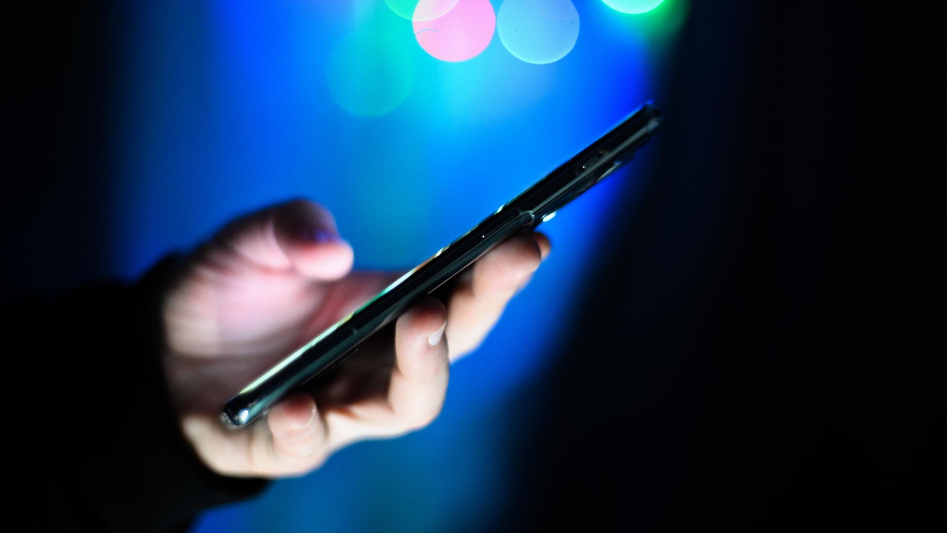 Мужчина держит в руках мобильный телефон