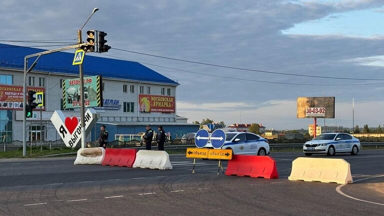 Сотрудники полиции дежурят неподалеку от места, где один из вагонов поезда Климов - Москва оказался раздавлен обрушившимся мостом