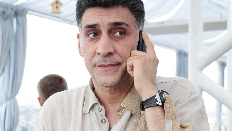 Режиссер Тигран Кеосаян разговаривает по телефону на вечеринке в честь Дня рождения журнала Русский пионер в Москве