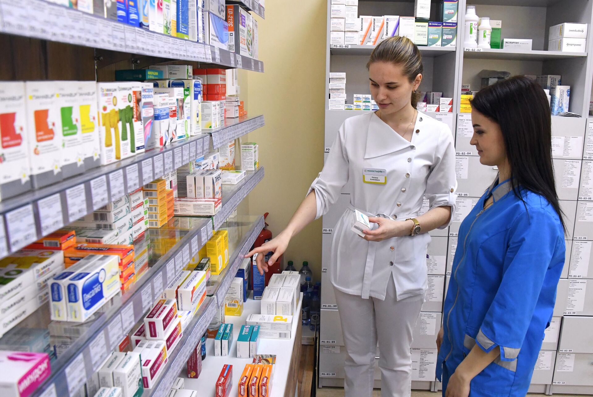 Фармацевты возле полок с лекарствами в аптеке. Архивное фото