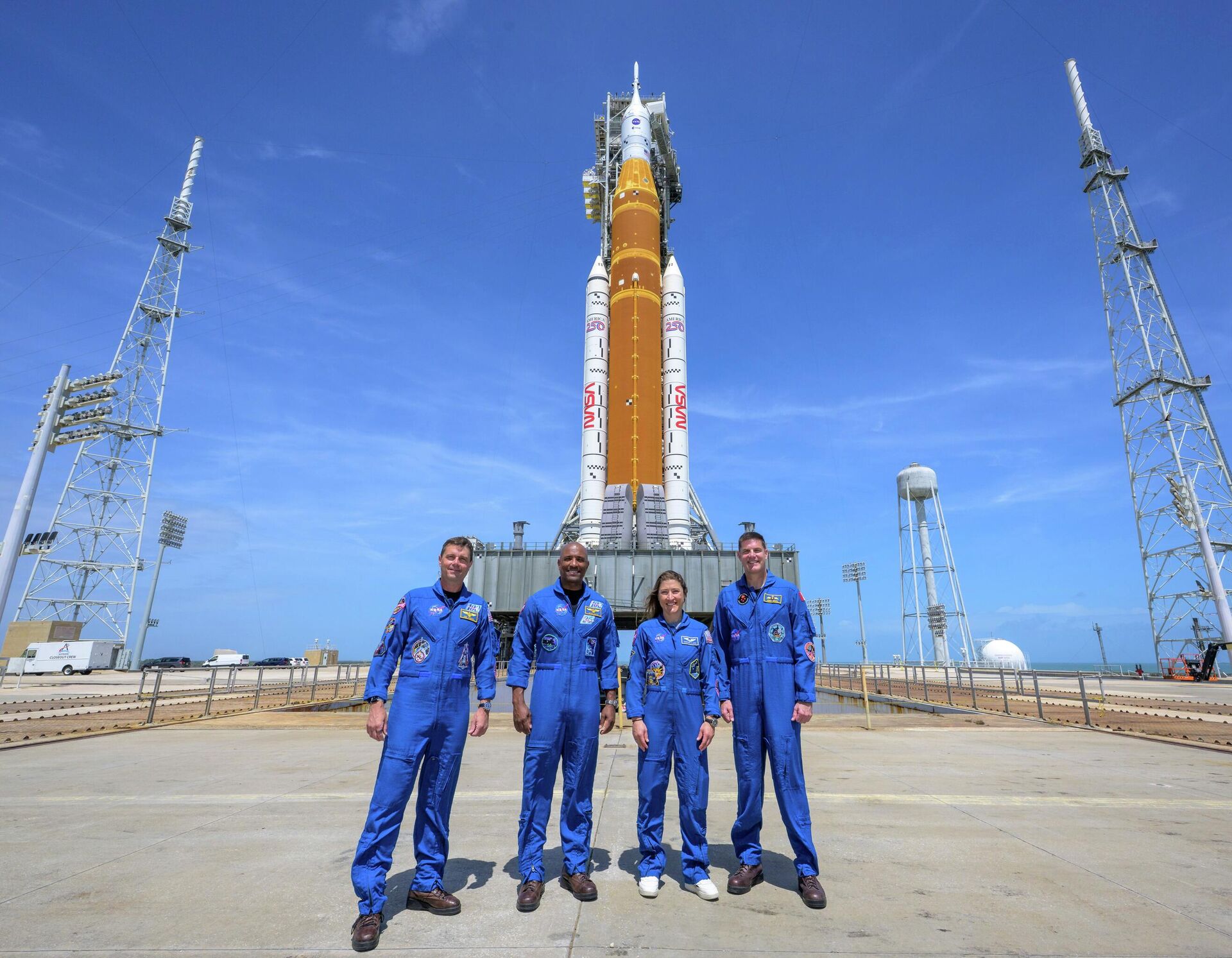 Астронавты НАСА Кристина Кук, Виктор Гловер, Грегори Уайсмен и астронавт ККА Джереми Хансен у ракеты Артемида-2
